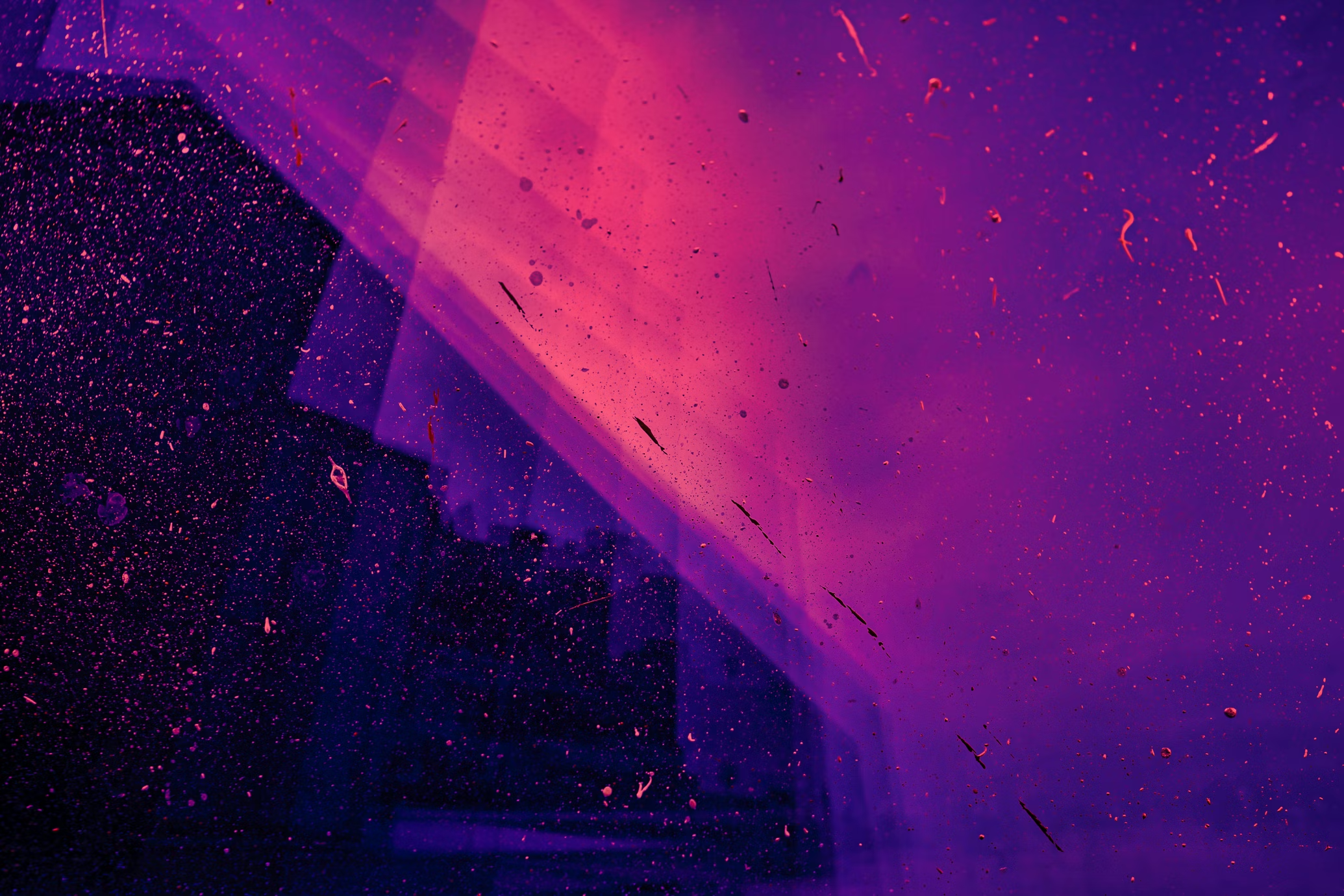 A black wall on a pink and purple sky.