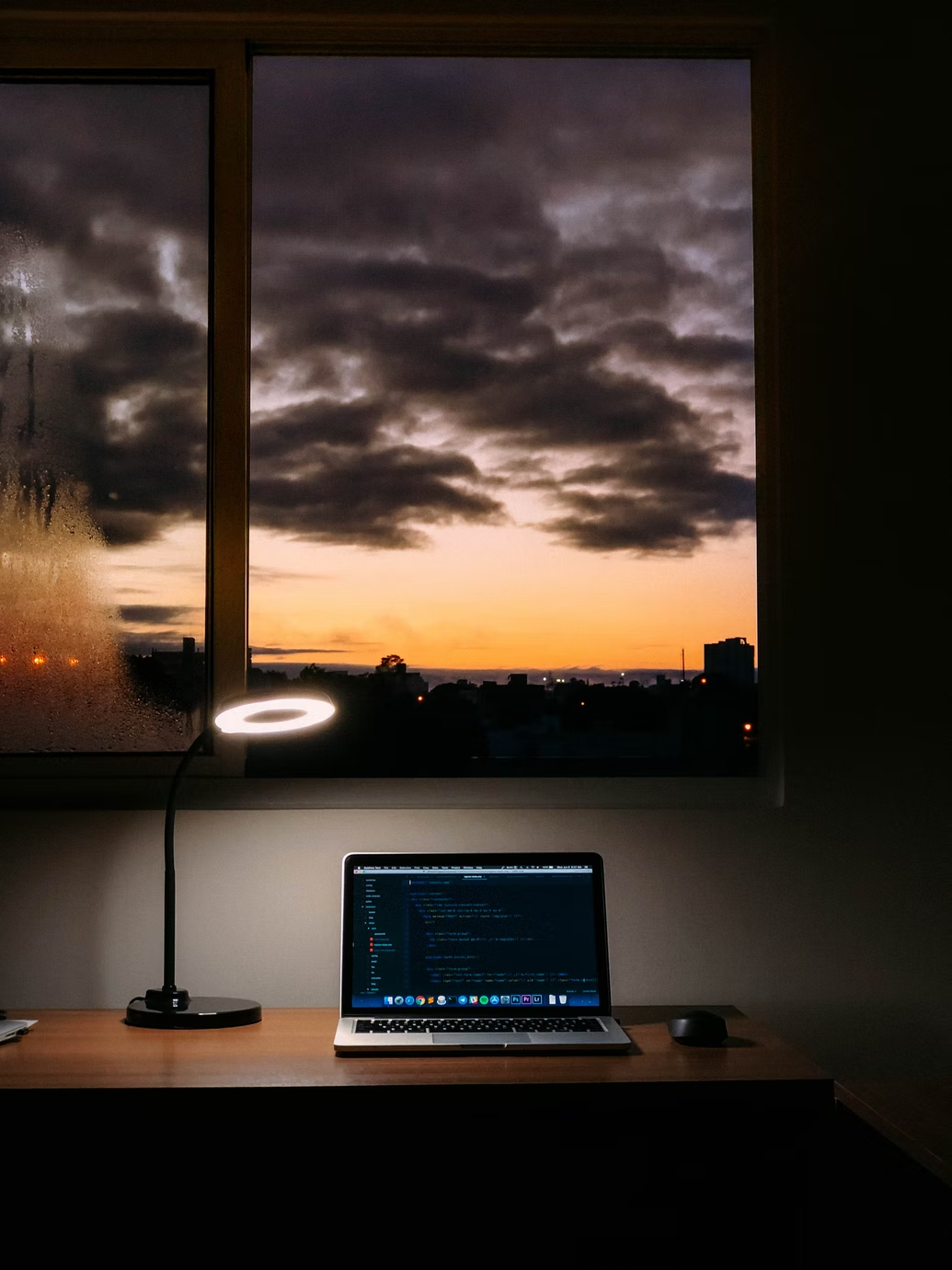 A computer and a lamp on a table.